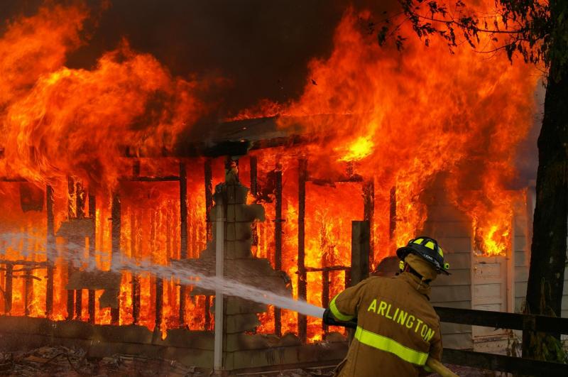 firefighter dousing a fire with water